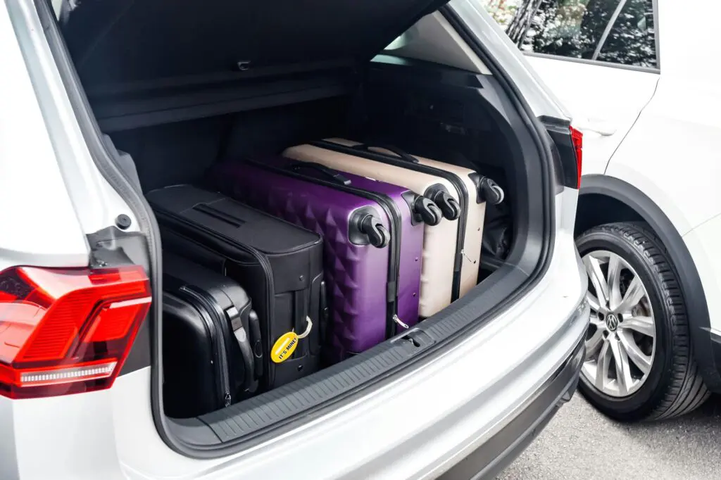 Suitcases packed in the trunk of a white SUV, indicating preparation for a trip. Chase Sapphire Preferred