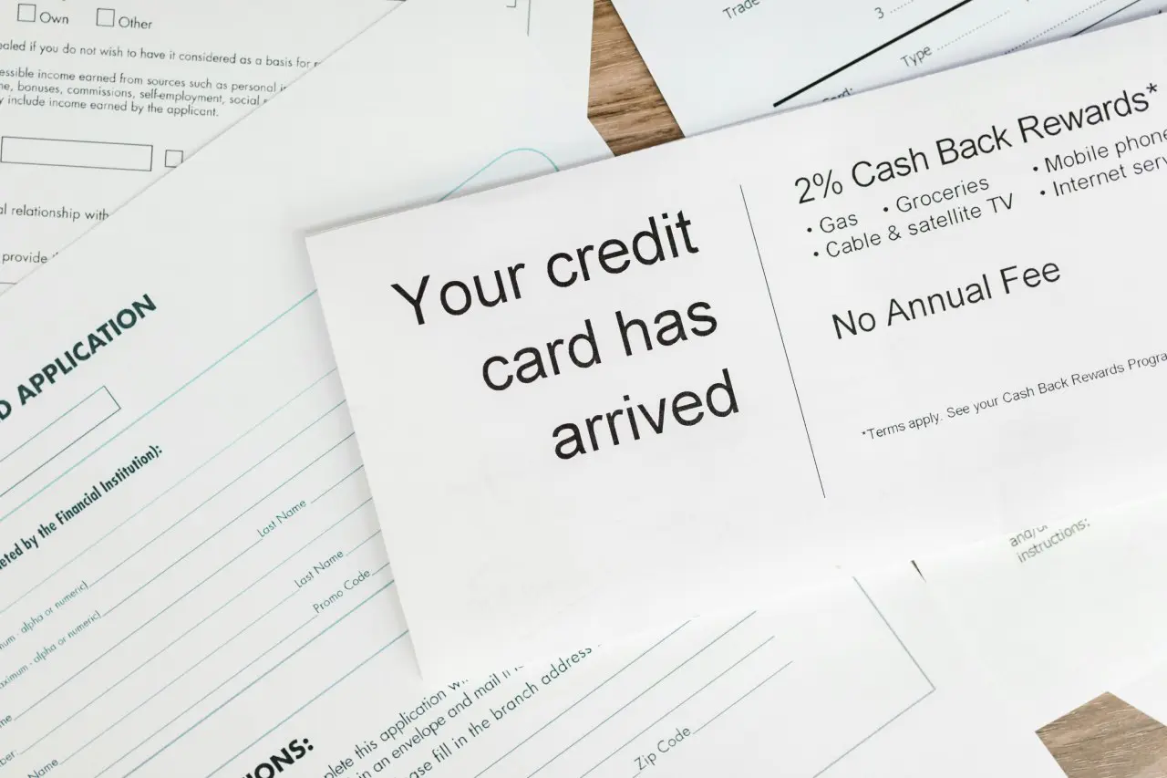 A close-up of various credit card application forms and promotional materials spread out on a table. Credit Card points