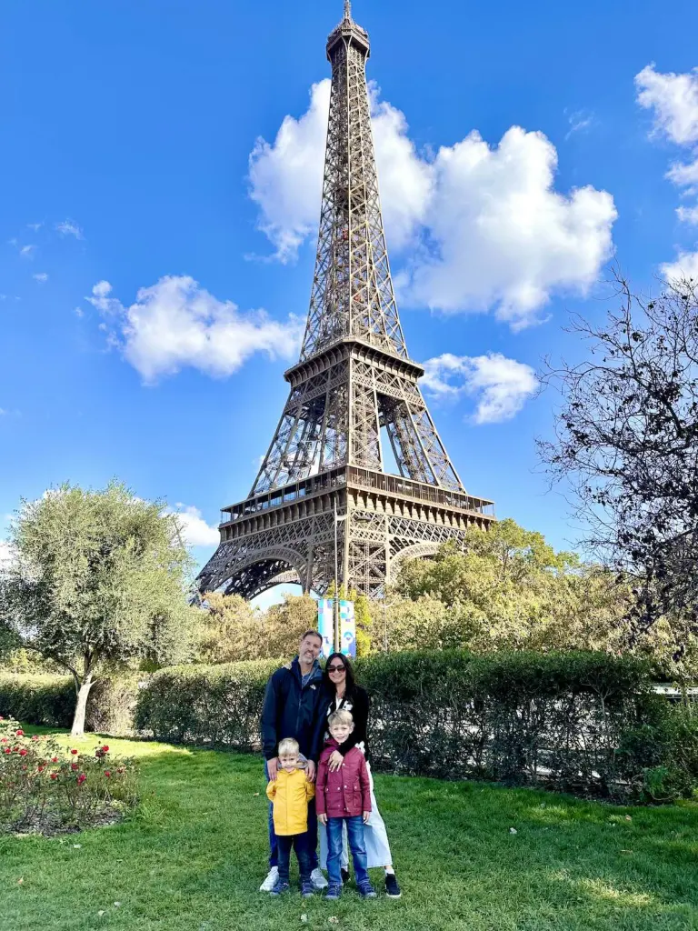 Family of four in front of the Eiffel Tower in Paris, France. credit card strategy