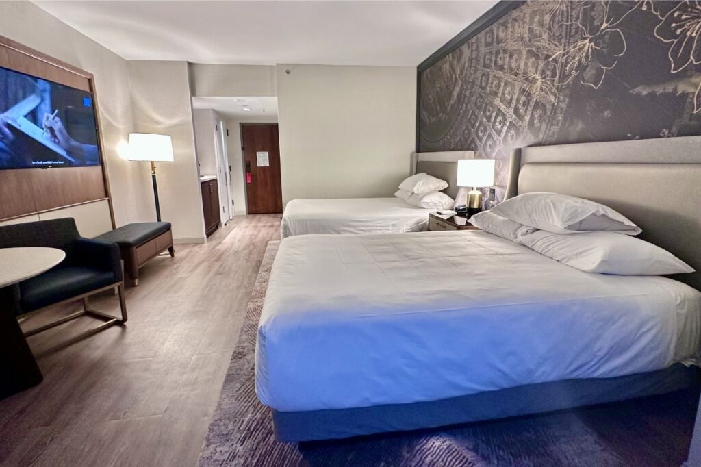 Cozy guest room at Hyatt hotel with modern furnishings, two double beds, and artistic wall decor. Hyatt hotels
