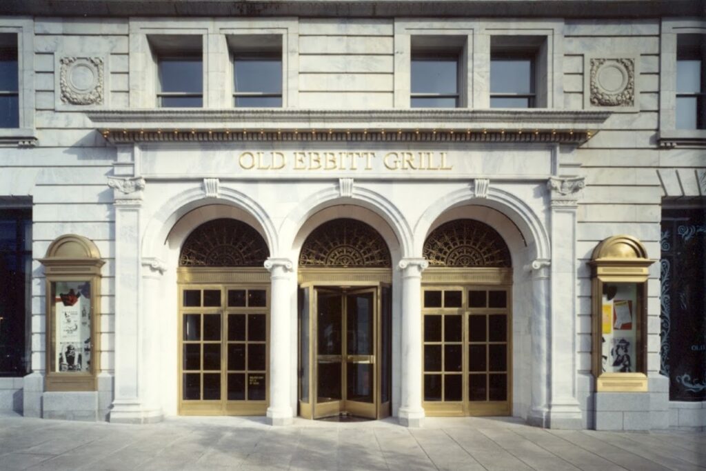 The grand entrance of Old Ebbitt Grill, in Washington DC. The restaurant's name is displayed in elegant gold lettering above the arches. DC Restaurants for Families