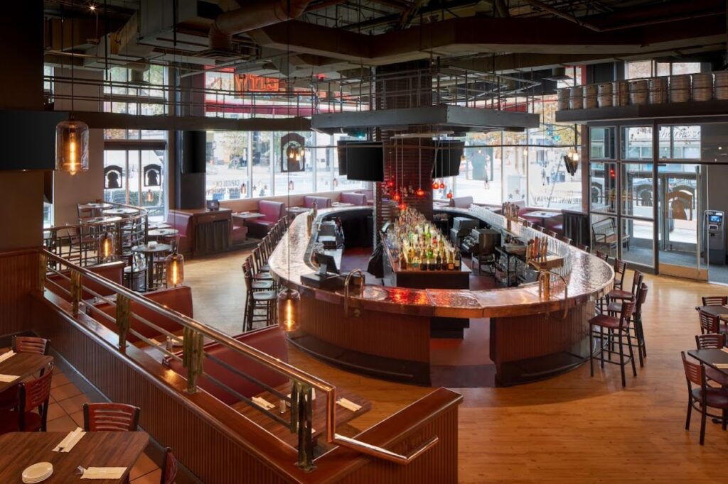 Capitol City Brewing Company restaurant interior featuring a large, curved bar with a polished countertop.