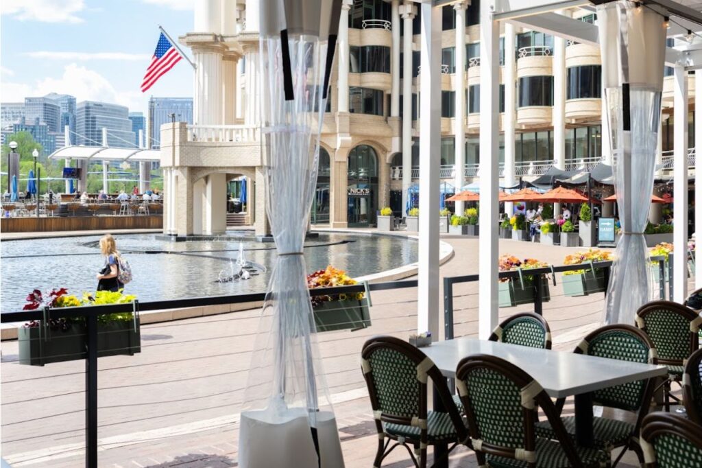 A scenic outdoor dining area overlooking a circular water fountain with gentle ripples. Founding Farmers, Georgetown Washington DC