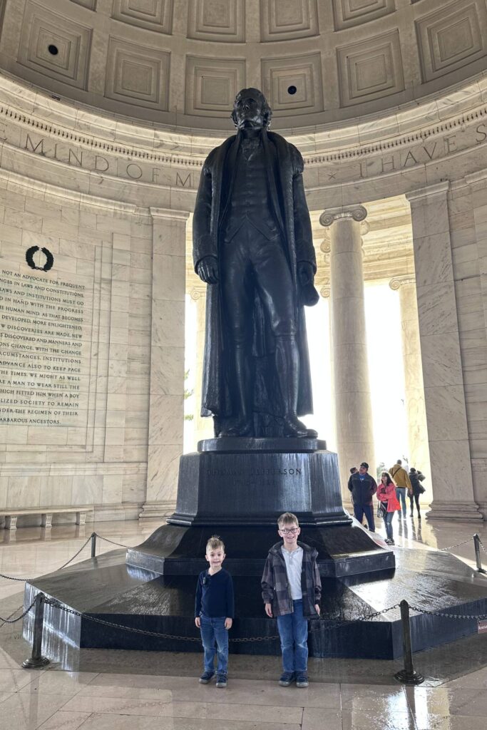 Two young boys standing near the base of the Jefferson statue inside the Jefferson Memorial. Washington DC Itinerary