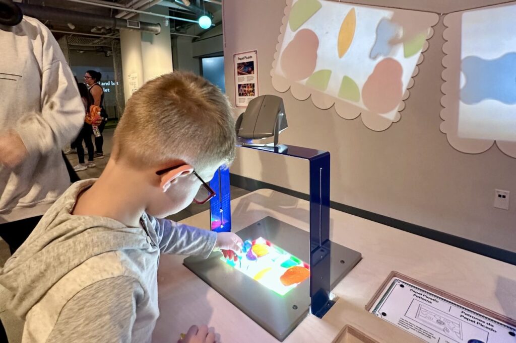 A child engaging with a colorful interactive exhibit at the National Children’s Museum, using a light table.