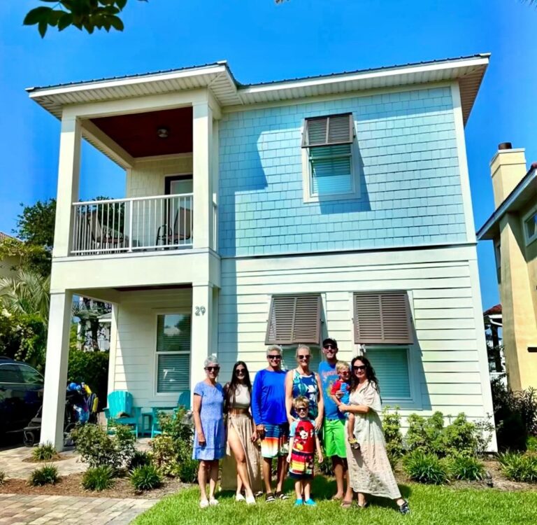 A large family stands in front of a HomeExchange in Miramar Beach, Florida