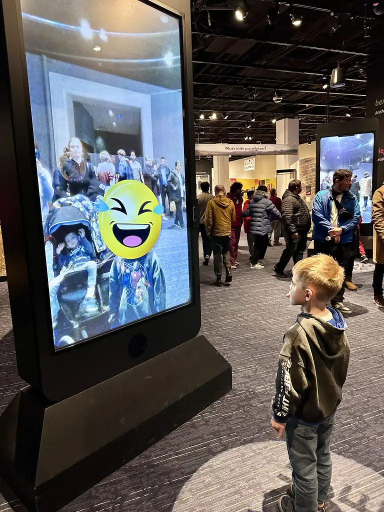 A little boy stands in front of a cellphone exhibit at the National History Museum in Washington, DC