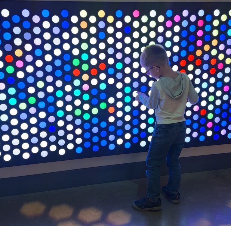 A young boy plays with a colorful wall at the National Children's Museum. Things to do in DC with Kids