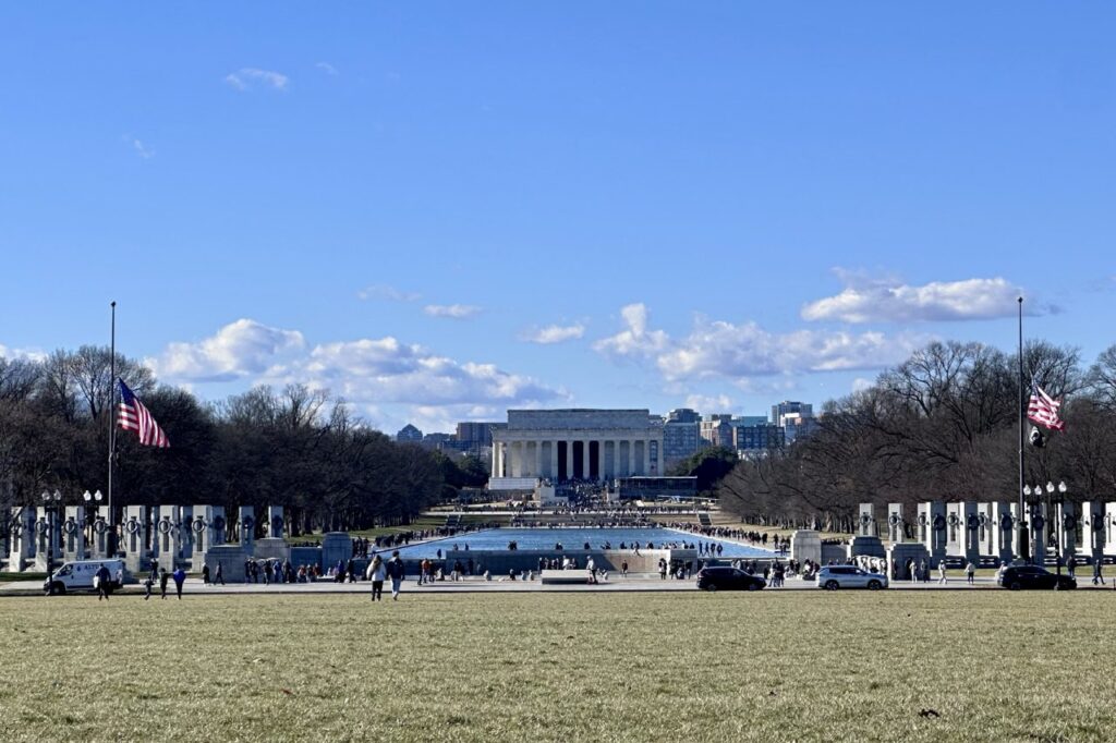 A wide view of the World War II Memorial with the Lincoln Memorial in the background.