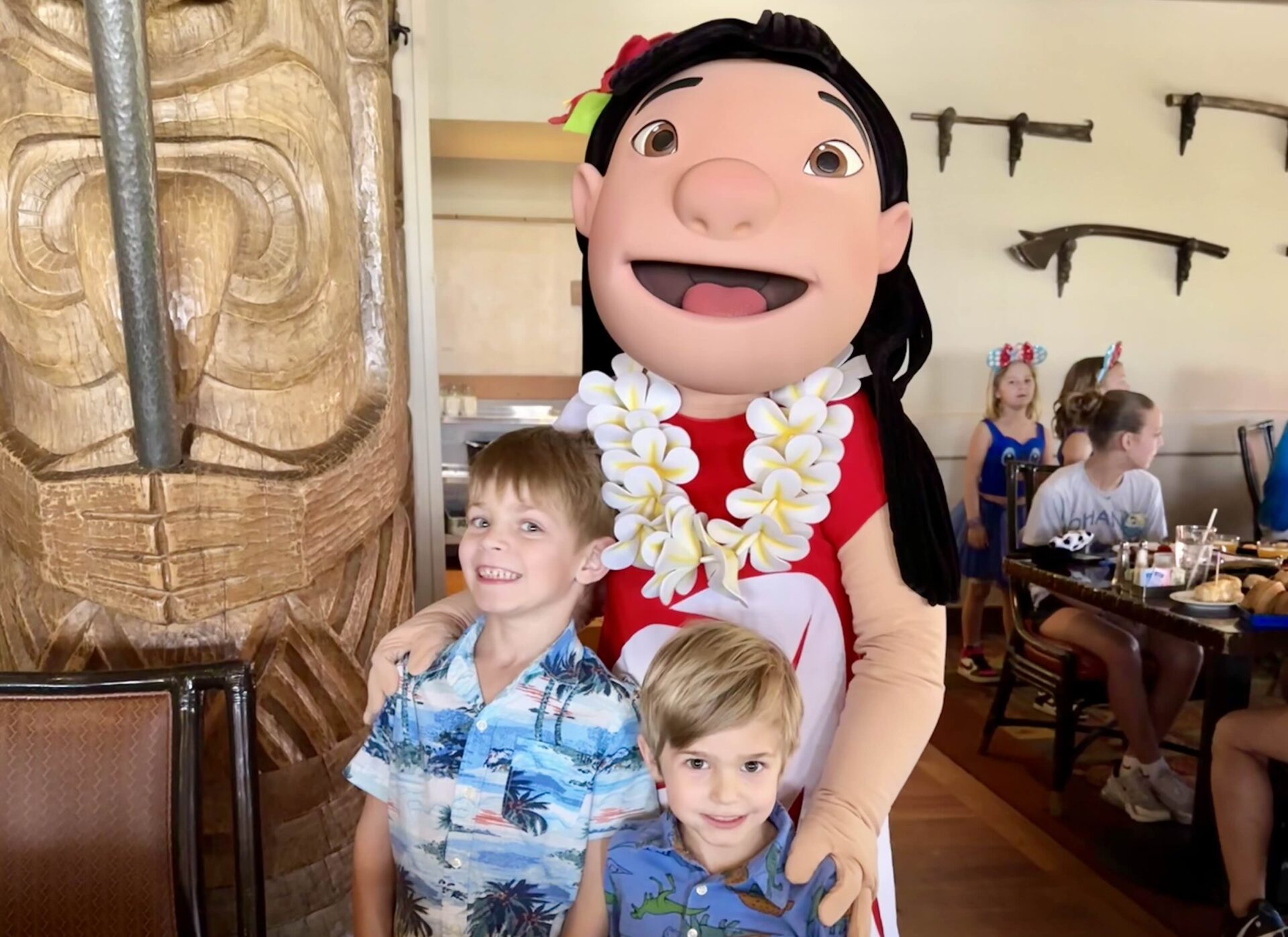 Two young boys posing with Lilo from "Lilo & Stitch" inside the ʻOhana character breakfast at Disney's Polynesian Village Resort.