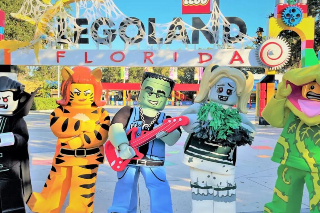 LEGOLAND Florida entrance decorated for Halloween with large LEGO characters dressed as a vampire, tiger, Frankenstein, zombie cheerleader, and plant monster. Best Places to Visit for Halloween