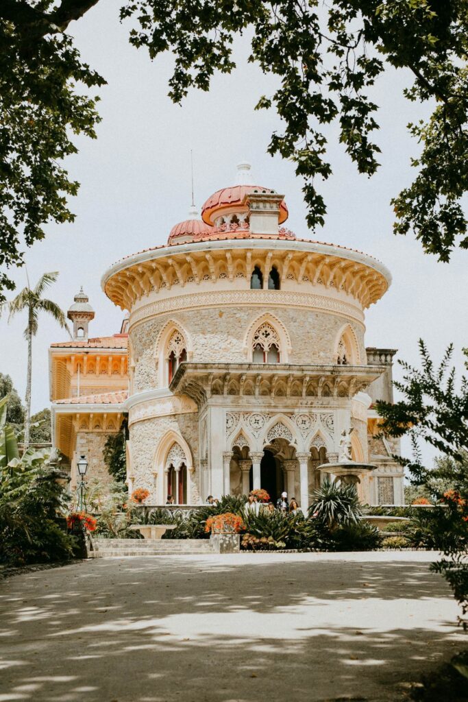 Monserrate Palace in Sintra, Portugal, a round building with red domes, arched windows, and detailed stonework surrounded by gardens.