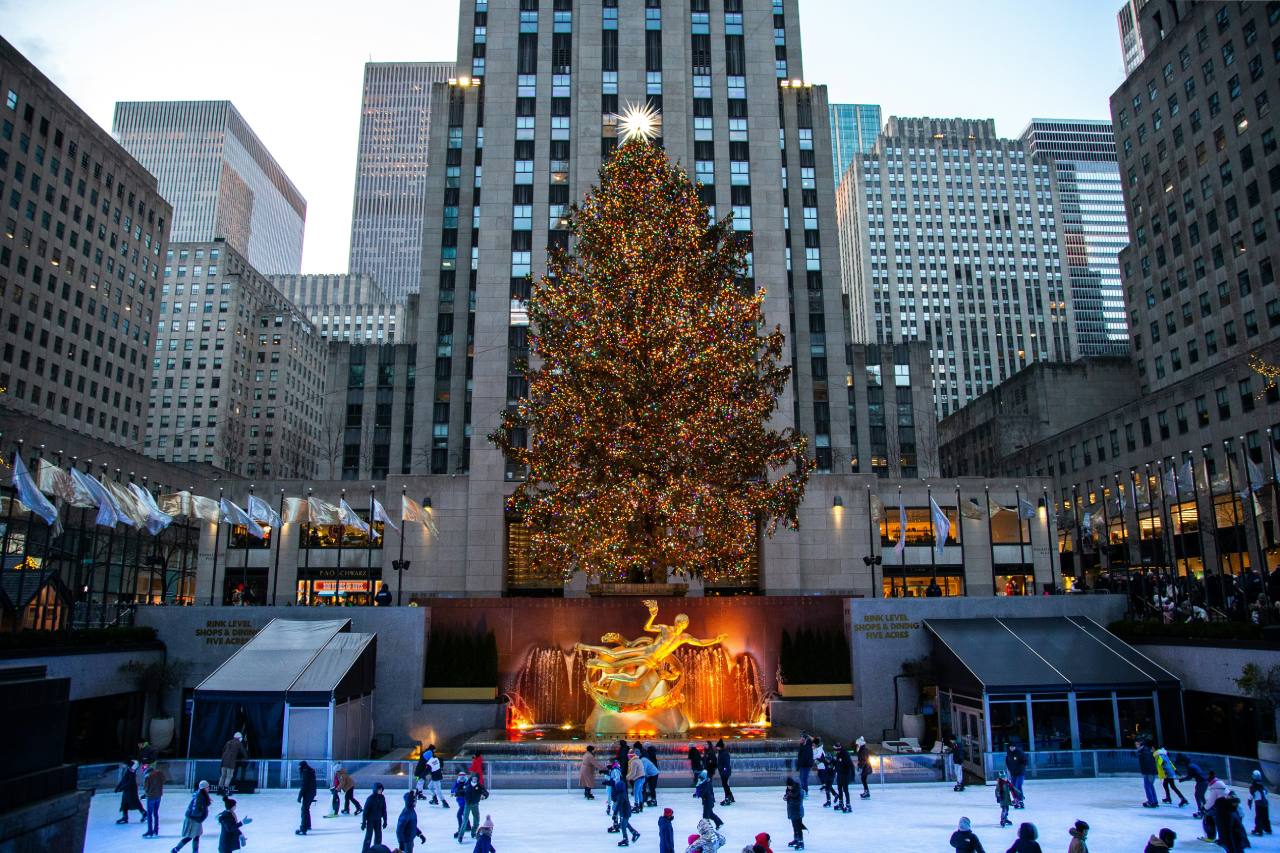 Skaters enjoying the Rockefeller Center ice rink with the Christmas tree in the background. Christmas vacations for families