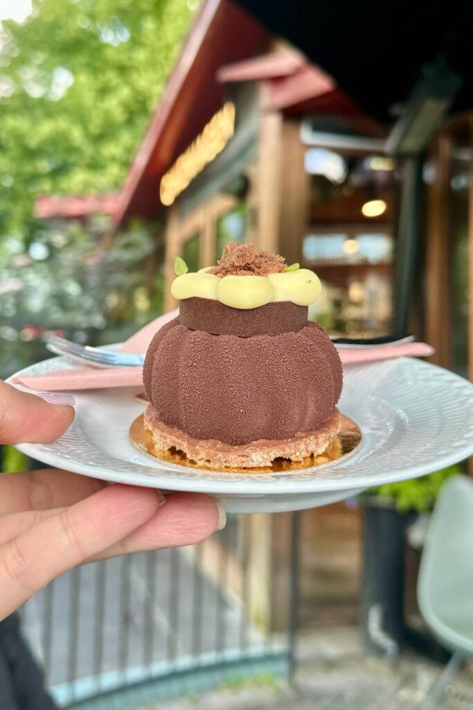 Chocolate mousse–style dessert with decorative topping held on a plate at Tivoli Gardens.