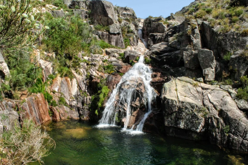 Waterfall cascading into a crystal-clear natural pool in Peneda-Gerês National Park, northern Portugal