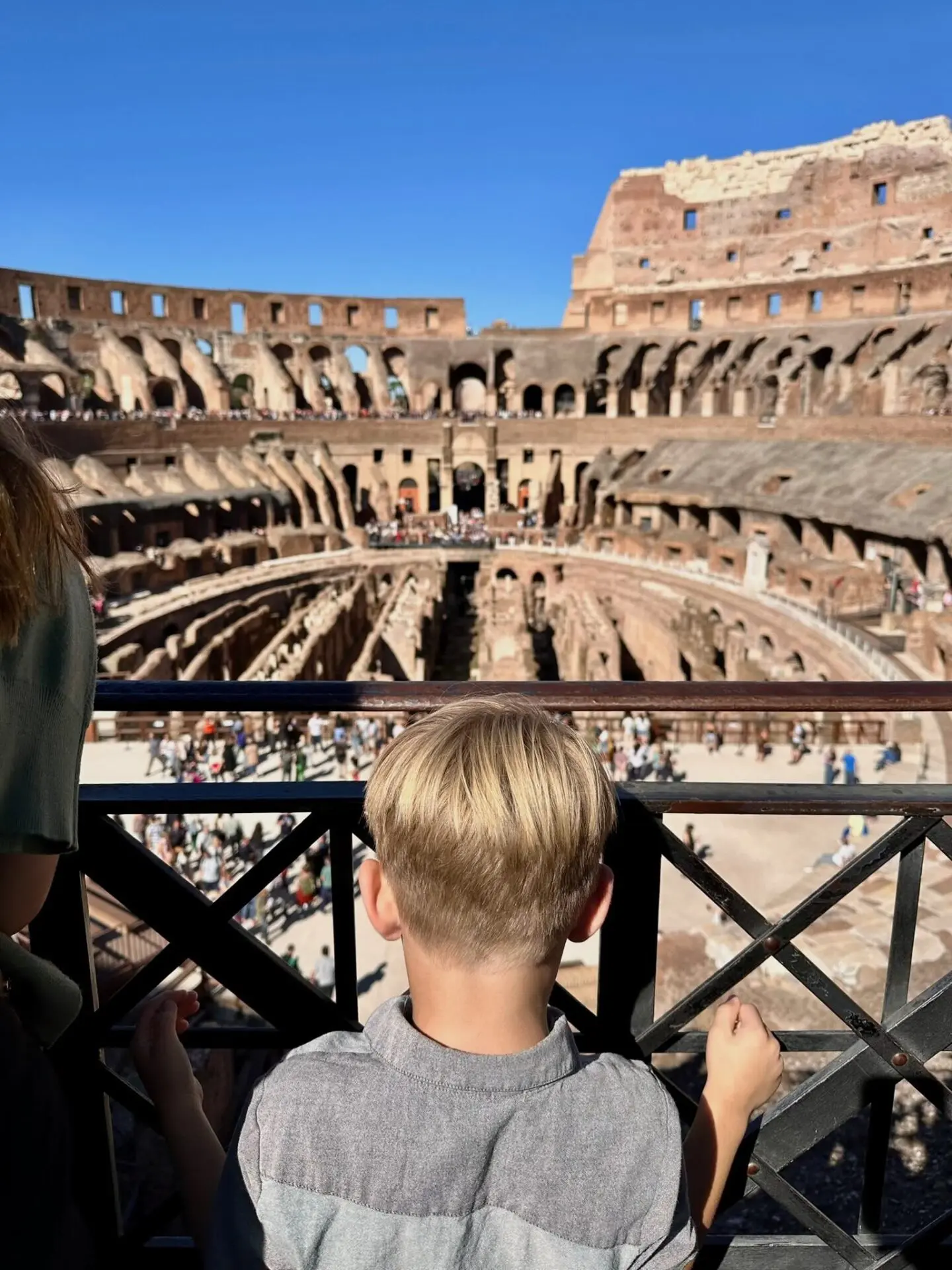 A boy looks at the ruins at the Colosseum Rome