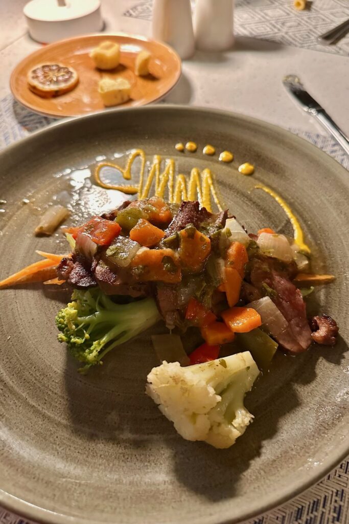 Sautéed duck with stir-fried vegetables on a ceramic plate at Tierra restaurant