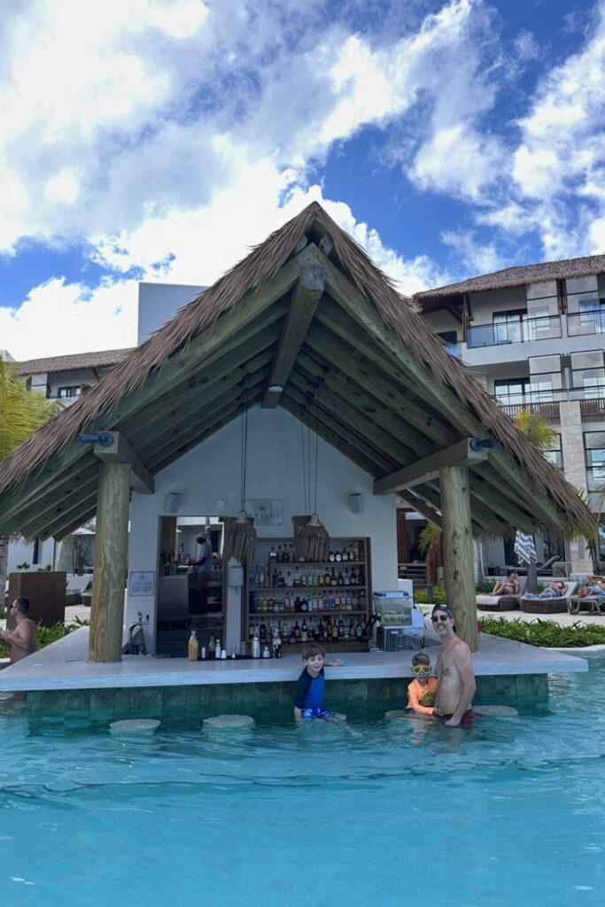 Dad and two kids at the swim-up bar in the family pool at Dreams Playa Esmeralda