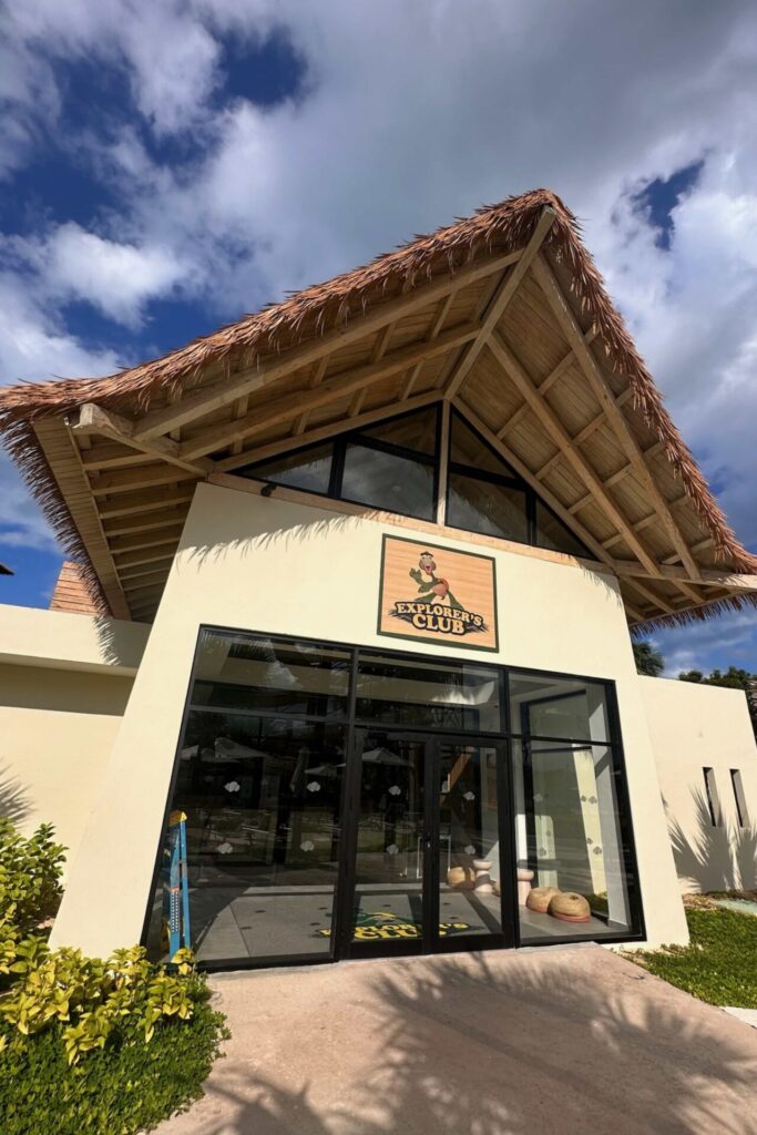 Exterior of the Explorer's Club kids club building at Dreams Playa Esmeralda with thatched roof and glass doors