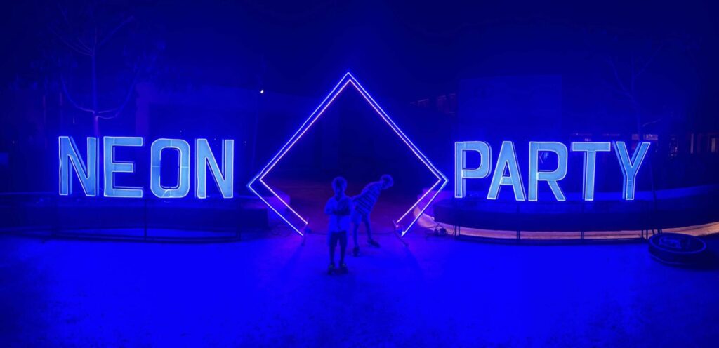 Neon Party night event at Dreams Playa Esmeralda with large illuminated "Neon Party" sign and blue lighting