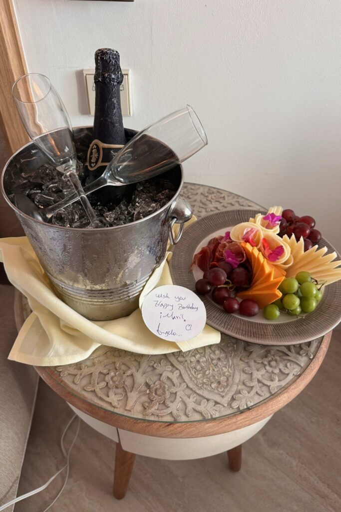 Birthday surprise in the hotel room at Dreams Playa Esmeralda with champagne on ice, fruit and cheese plate, and handwritten note
