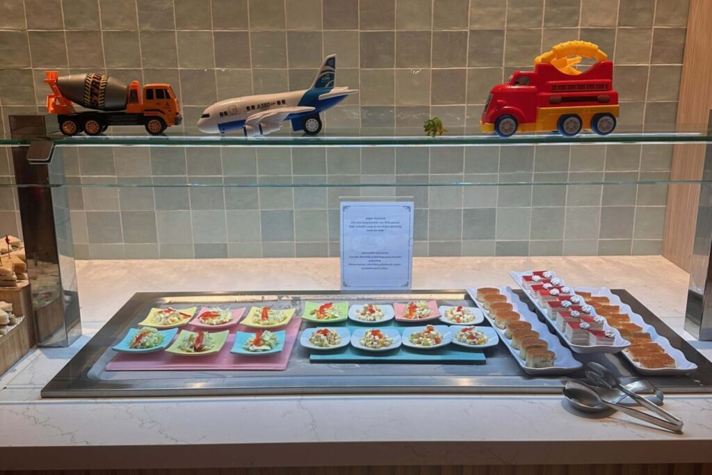 Kids buffet station at Dreams Playa Esmeralda with colorful plates of food and toy vehicles on display