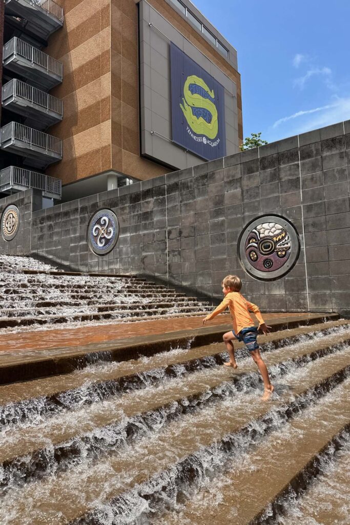 Boy playing in the free fountain steps below the Aquarium Scuttlebutt exhibit in Chattanooga