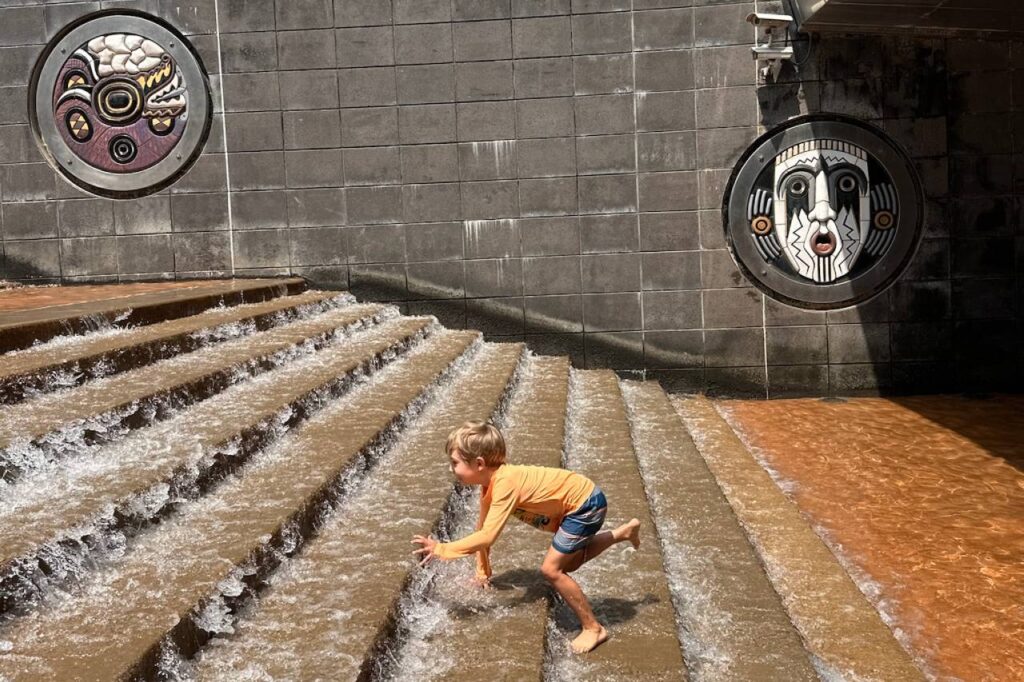 Young boy running up the splash fountain steps outside the Tennessee Aquarium