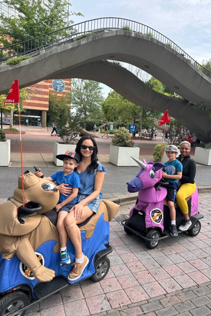 Family riding motorized Rydables, a unicorn and a seal, near the Aquarium in downtown Chattanooga