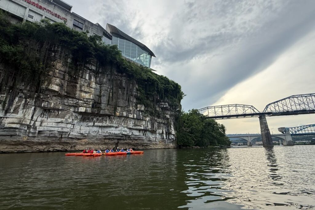 Kayak tour group on the Tennessee River with downtown Chattanooga bridges in the distance