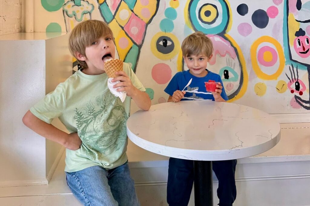 Two boys eating ice cream in front of a colorful mural at Clumpie's in Chattanooga