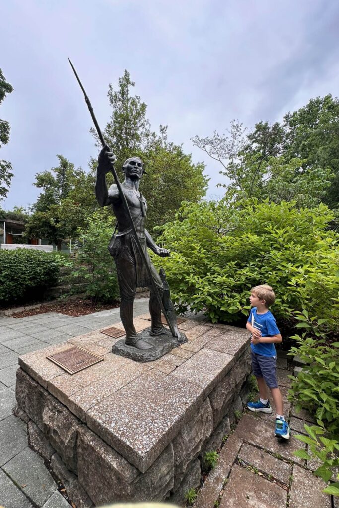 Young boy gazing up at a bronze Cherokee warrior statue near Ross's Landing in Chattanooga
