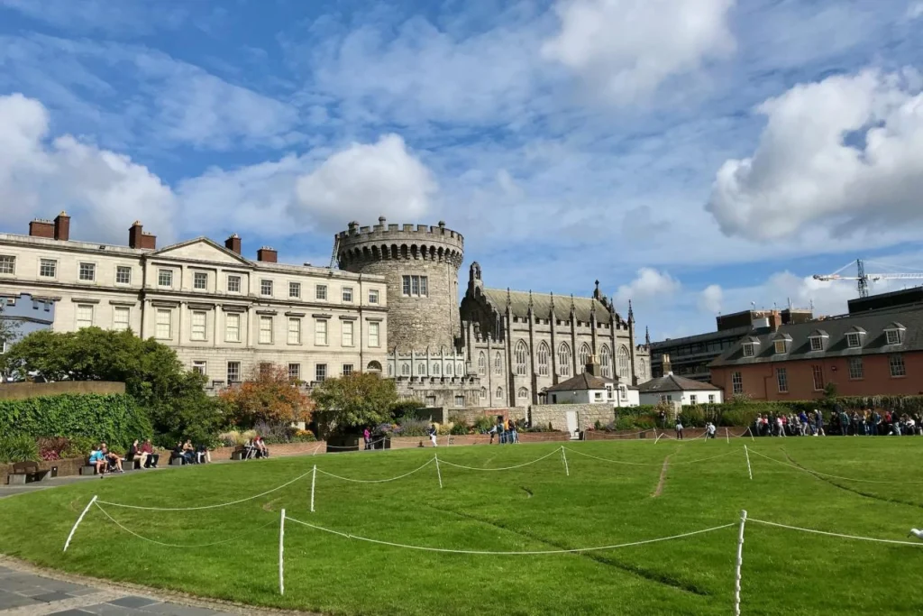Dublin Castle in Ireland with the round Record Tower, the Chapel Royal, and a wide green lawn in the foreground.