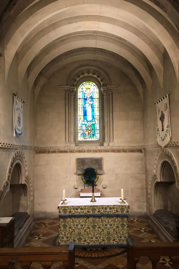 Small side chapel inside Christ Church Cathedral in Dublin, Ireland, with a stained glass window, stone altar, and vaulted ceiling.