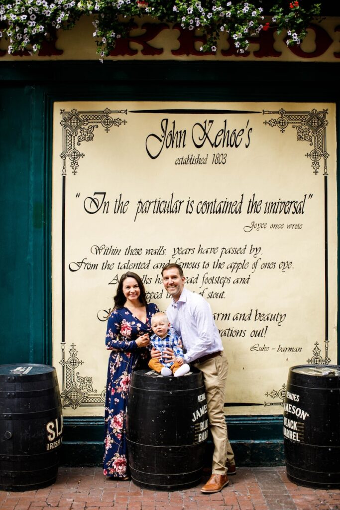 Family of three in front of a sign in Dublin Ireland