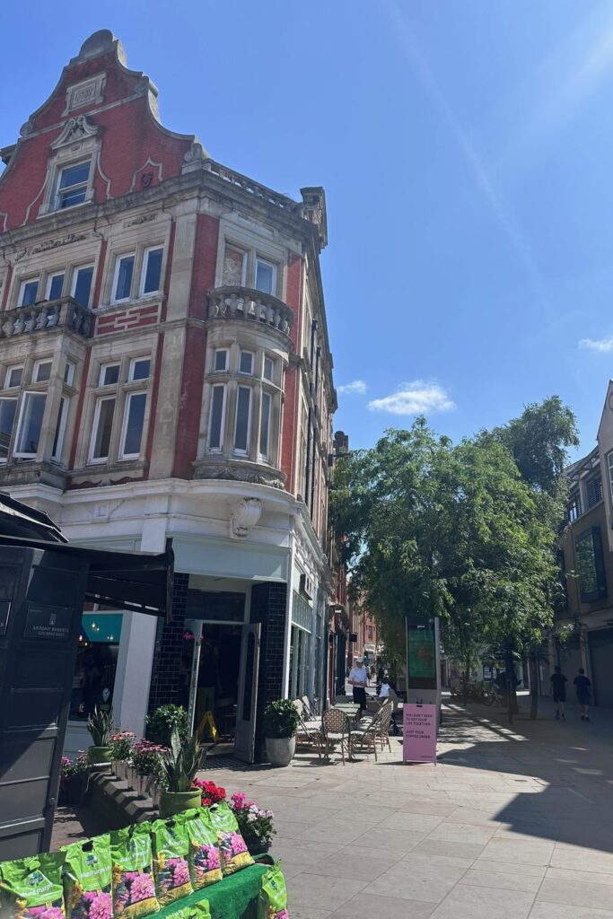 Red brick Victorian buildings and outdoor cafe seating on George Street in Richmond London on a sunny day