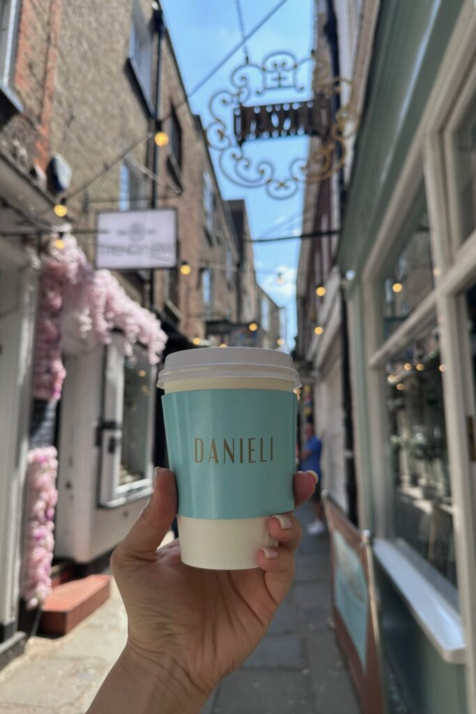 Holding a Danieli coffee cup in Brewer's Lane, one of the prettiest things to do in Richmond London