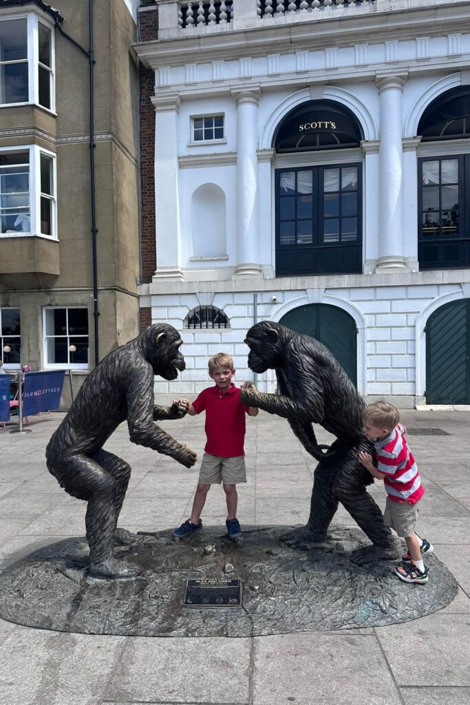 The Alex and Owen chimpanzee sculptures on Richmond Riverside with two children climbing on them