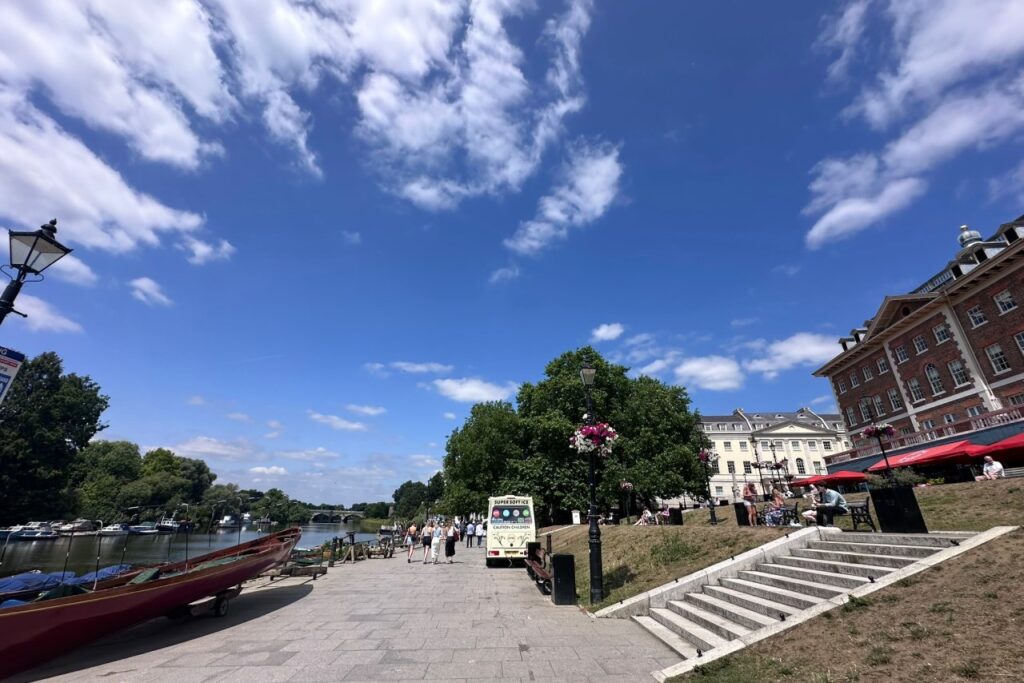 Wide riverside promenade at Richmond Riverside with an ice cream van and people walking beside the Thames