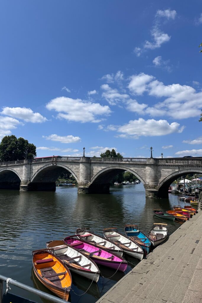 Colorful rowing boats for hire lined up beneath Richmond Bridge on the River Thames
