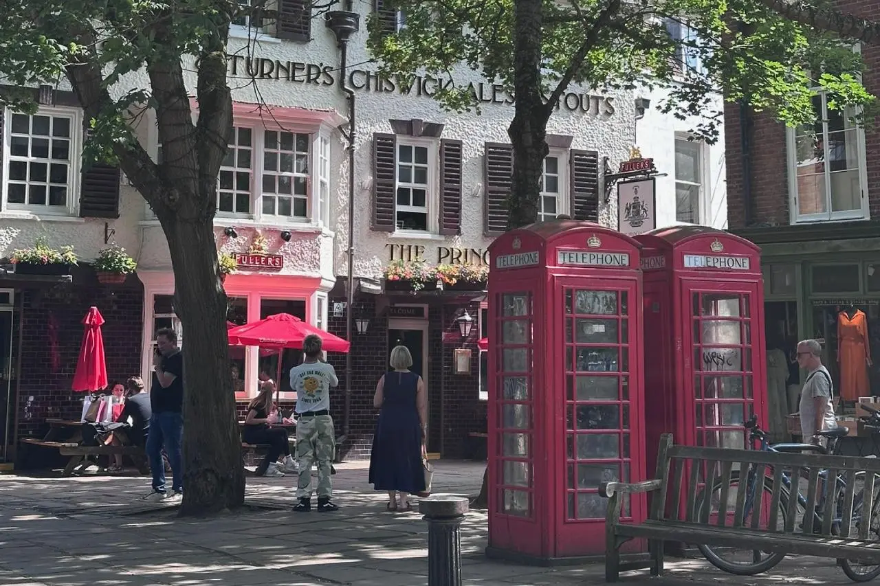 The Prince's Head pub on Richmond Green with two red phone boxes and the Ted Lasso bench