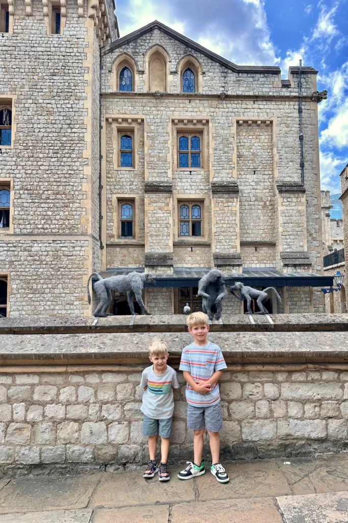 Two brothers below the wire monkey sculptures at the Tower of London, part of the Royal Beasts display. Things to do in London
