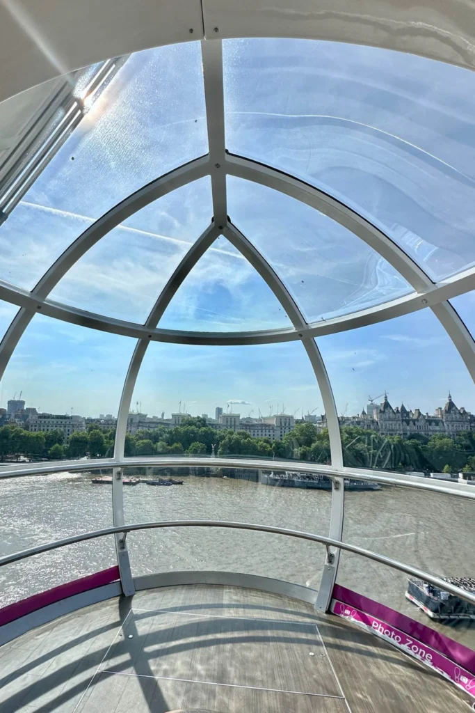 Inside a London Eye capsule looking out over the Thames toward Westminster.