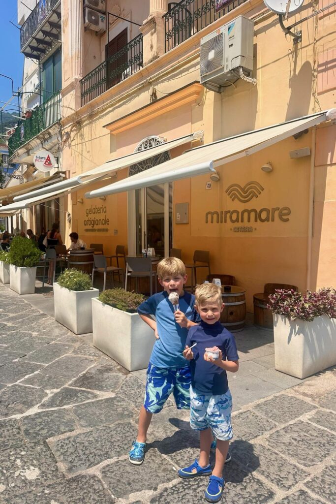 Two boys in swim shirts eating gelato outside Miramare gelateria artigianale in Cetara
