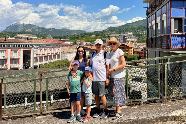 Mari, her sons and her parents at an overlook above a small southern Italian town with green mountains behind