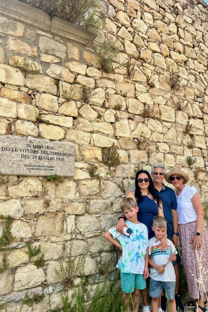 Mari, her two sons and her parents beside the memorial plaque for the victims of the 1930 earthquake in Aquilonia, Italy
